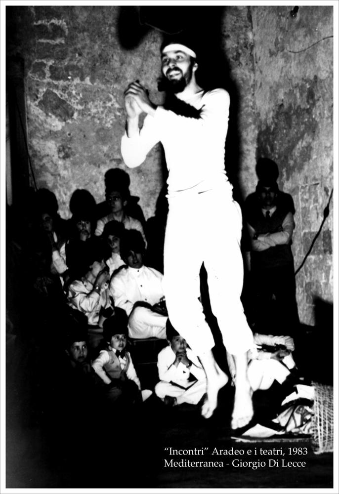 L'immagine digitale cattura uno dei momenti della performance di Giorgio Di Lecce, messa in scena a luglio del 1983 nell'ambito della rassegna “Aradeo e i Teatri” inaugurata in quell'anno con il titolo “Incontri”, un appuntamento con il teatro sperimentale. La manifestazione fu organizzata dal circolo culturale “S.M. Ejzenstein” per colmare, attraverso la messa in scena di spettacoli di teatro e danza, la mancanza di confronto fra culture differenti molto sentita dalla cittadinanza di Aradeo. Giorgio di Lecce, storico della danza ed antropologo, è stata figura cardine della ricerca scientifica sulla musica del Salento e della ricerca per lo spettacolo e per la progettazione di culture teatrali e fu fondatore, insieme a Cristina Ria, di “Mediterranea - Laboratorio dello ...