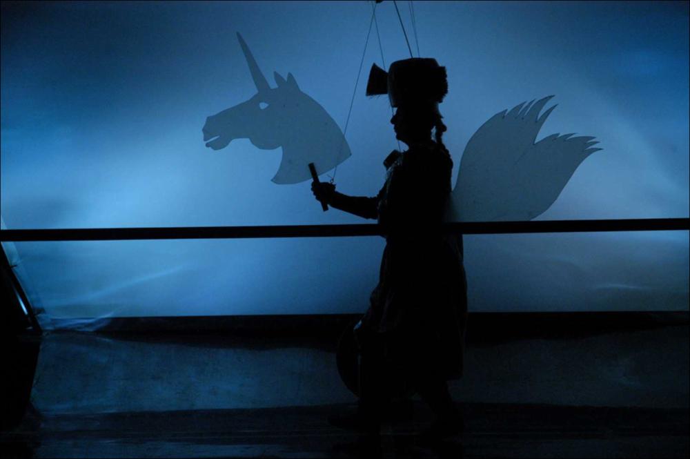 La fotografia in oggetto, ad opera di Elisa Manta, immortala un momento dello spettacolo “Paladini di Francia”, messo in scena dai Cantieri Teatrali Koreja di Lecce per la stagione 2015-2016 dedicata al Teatro Ragazzi. Giochi di bambini, marionette e pupi prendono vita per inscenare uno spettacolo colto e coinvolgente, ricco di citazioni e pure fluente: lo spettacolo di Francesco Niccolini, regia di Enzo Toma, è avvincente sapendo divertire, aprendo intanto spazi di commozione e delicata poesia nell'amata cornice di "Cosa sono le nuvole?" di Pier Paolo Pasolini, fonte d'ispirazione anche per la definizione dei personaggi, attori/pupi che ruotano intorno al loro Imperatore Carlo Magno. È in fondo la storia comica e tragica dei paladini di Carlo Magno, dall'arrivo a corte...