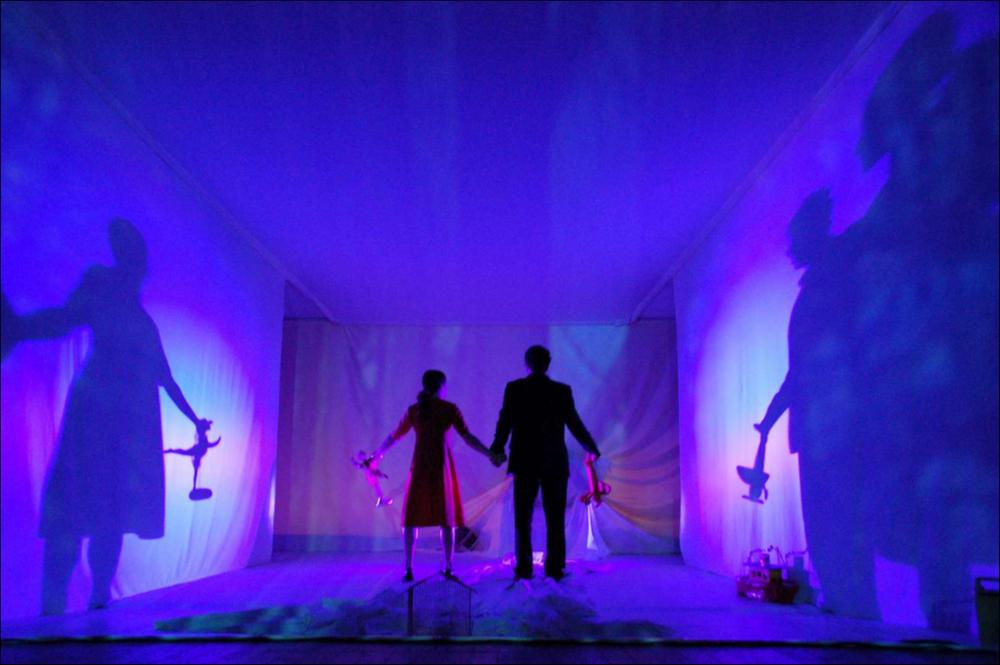 L'immagine in oggetto, fotografia ad opera di Tony D'Urso, cattura un momento dello spettacolo di “Hansel e Gretel - Mangiadisk”, una delle produzioni 2015-2016, messe in scena dalla compagnia teatrale Koreja di Lecce. Lo spettacolo, di Francesco Niccolini per la regia di Enzo Toma interpretato da Alessandra Crocco, Carlo Durante e Silvia Ricciardelli racconta la storia di due fratelli che, oramai adulti, ritornano nella casa dove trascorrevano le vacanze durante la loro infanzia. Lì ad aspettarli trovano la loro anziana nonna e un mangiadischi: un richiamo alla più celebre fiaba di “Hansel e Gretel”, che per molte notti aveva accompagnato i sogni/incubi dei piccoli fratelli. I ricordi riaffiorano, permettendo finalmente di esorcizzare i cattivi pensieri e la nonna, nel...