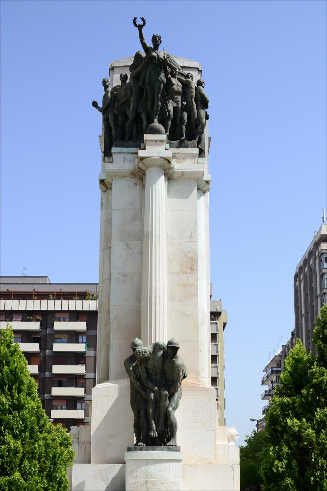 L'immagine digitale cattura uno dei lati dell'imponente Monumento ai Caduti di Taranto. Inaugurato nel novembre del 1930 alla presenza del re Vittorio Emanuele III, è il più grande monumento del Borgo Nuovo collocato al centro di Piazza della Vittoria, a pochi passi dal corso principale cittadino. Ideato e disegnato dallo scultore originario di Taranto Francesco Paolo Como, è di tipo "a cippo", realizzato in pietra calcarea di Trani con quattro gruppi di statue in bronzo. Nella parte superiore, da un lato un gruppo di soldati è accompagnato da Atena, dea della guerra, dall'altro da Vittoria (in foto), la dea della vittoria in battaglia; in quella inferiore, un gruppo, denominato Aquilifero, rappresenta un soldato nell'atto di scagliare in volo un'aquila, sull'altro lato...