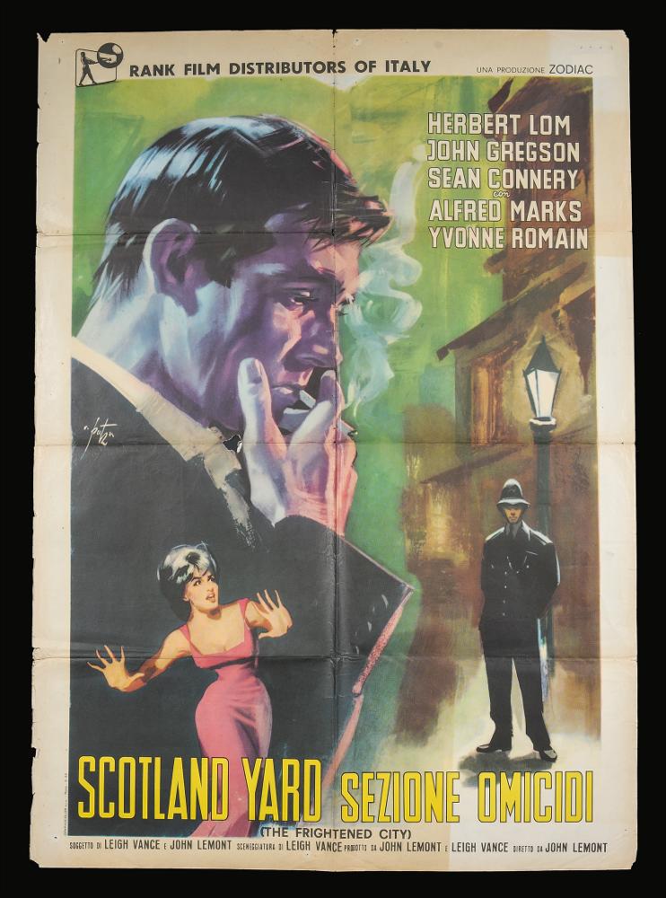 L'immagine riproduce uno dei manifesti conservati presso la Mediateca Regionale Pugliese (vedi Note). Si tratta di una delle versioni grafiche per il manifesto del film "Scotland Yard – Sezione omicidi" del 1961 per la regia di John Lemont a firma dell’illustratore romano Arnaldo Putzu, collaboratore di Enrico De Seta e dello studio Favalli. Lo stile di Putzu è riconoscibile per la drammaticità del suo tratto e della scelta dei momenti rappresentati, qui suddivisi in tre scene. Bellissimo il grande profilo e mezzo busto del protagonista, rappresentato con le sfumature del bianco e nero, particolare la scelta di inserire alla sua base la protagonista femminile che sembra spingersi contro una parete. Sullo sfondo una strada londinese, con i palazzi sfumati che quasi si co...