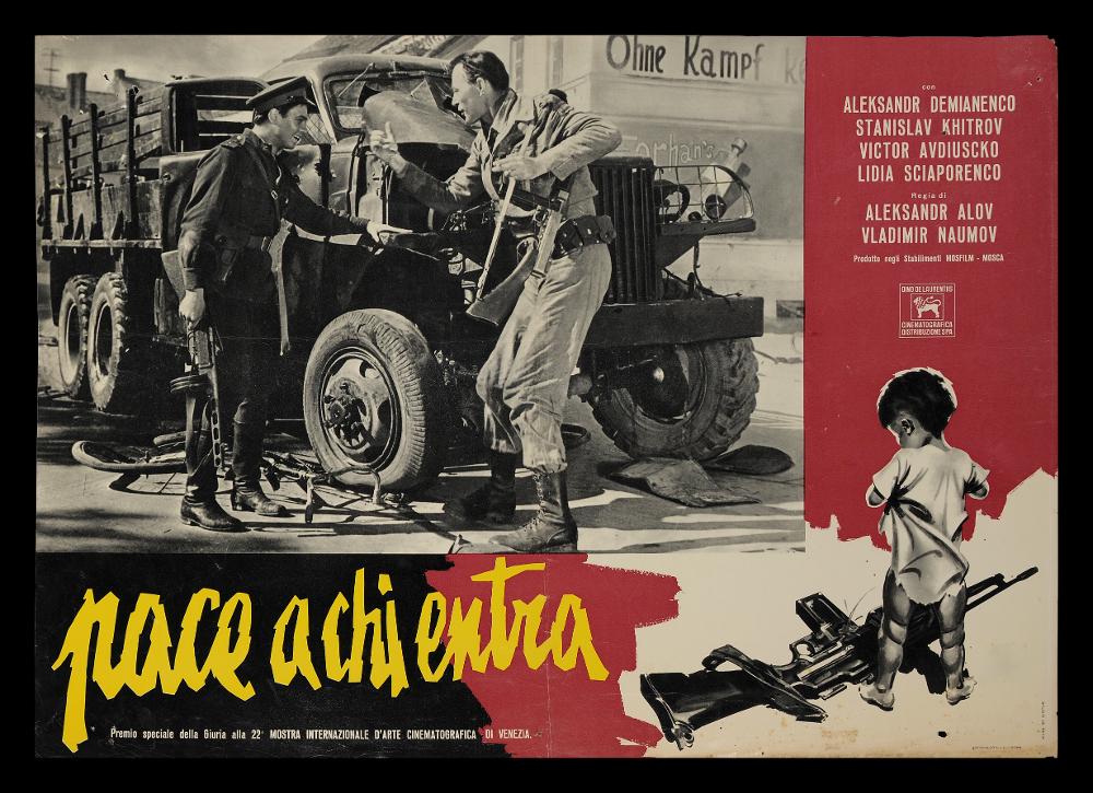 L'immagine riproduce uno dei manifesti conservati presso la Mediateca Regionale Pugliese (vedi Note). Si tratta di una delle fotobuste del film "Pace a chi entra" del 1961 per la regia di Aleksandr Alov e Vladimir Naumov. La fotobusta è stata realizzata dallo Studio De Seta e presenta come corpus centrale una fotografia in bianco e nero tratta da una scena del film. Nella cornice laterale è disegnato, sempre in bianco e nero, un bambino piccolo di spalle che fissa il fucile ai suoi piedi, immagine che richiama subito la tematica del film. Significativa il lettering utilizzato per il titolo, un corsivo minuscolo dai contorni frastagliati ed incerti, scelta che evoca un senso di tremore e paura....