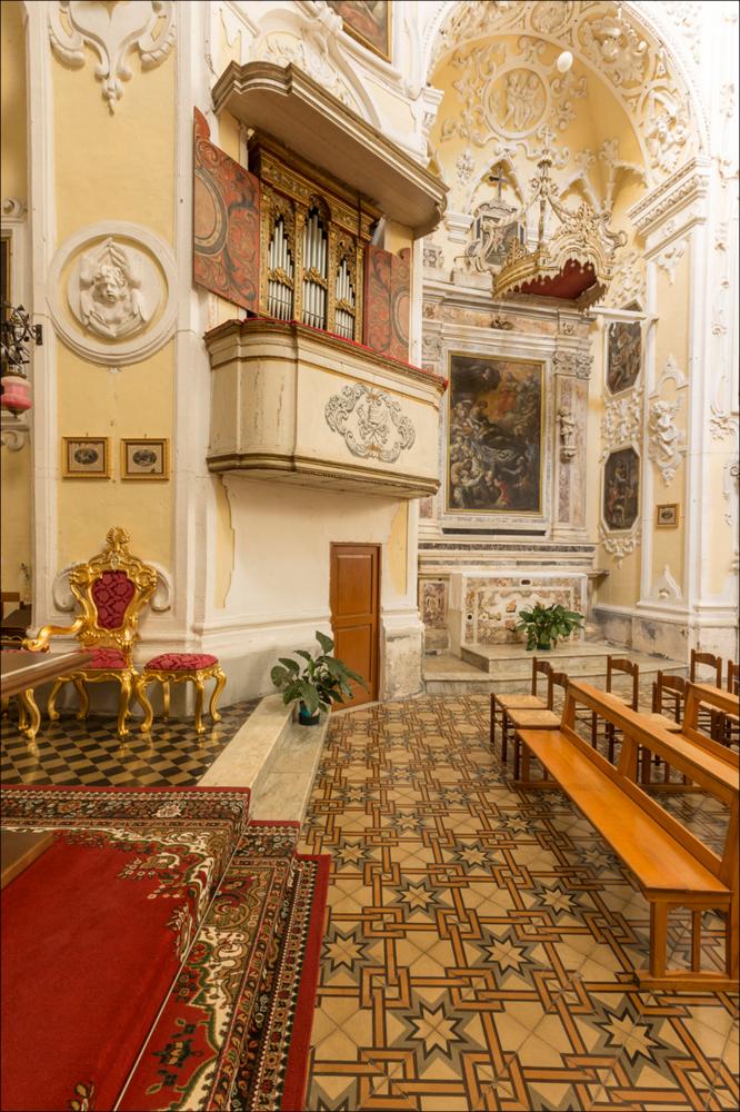 L’organo raffigurato nell'immagine digitale è collocato nella chiesa del Carmine di Manduria. La chiesa viene fondata dagli Scolopi nel 1681 da Giacomo Antonio Carrozzo. I lavori di costruzione iniziarono nel 1701 e terminarono nel 1741 (come ricorda la targa nel timpano della facciata), mentre il convento fu terminato nel 1745. La facciata a due ordini presenta nel piano inferiore un portale monumentale con un timpano triangolare spezzato, ai lati i due ingressi minori sormontati da due nicchie con le statue delle sante Irene e Barbara. Il secondo piano diviso da una balaustra, su cui sono collocate le statue degli Evangelisti, è leggermente arretrato, così da costituire uno scenografico affaccio sulla piazza. Inizialmente la chiesa era intitolata ai Santi Pietro e Pao...