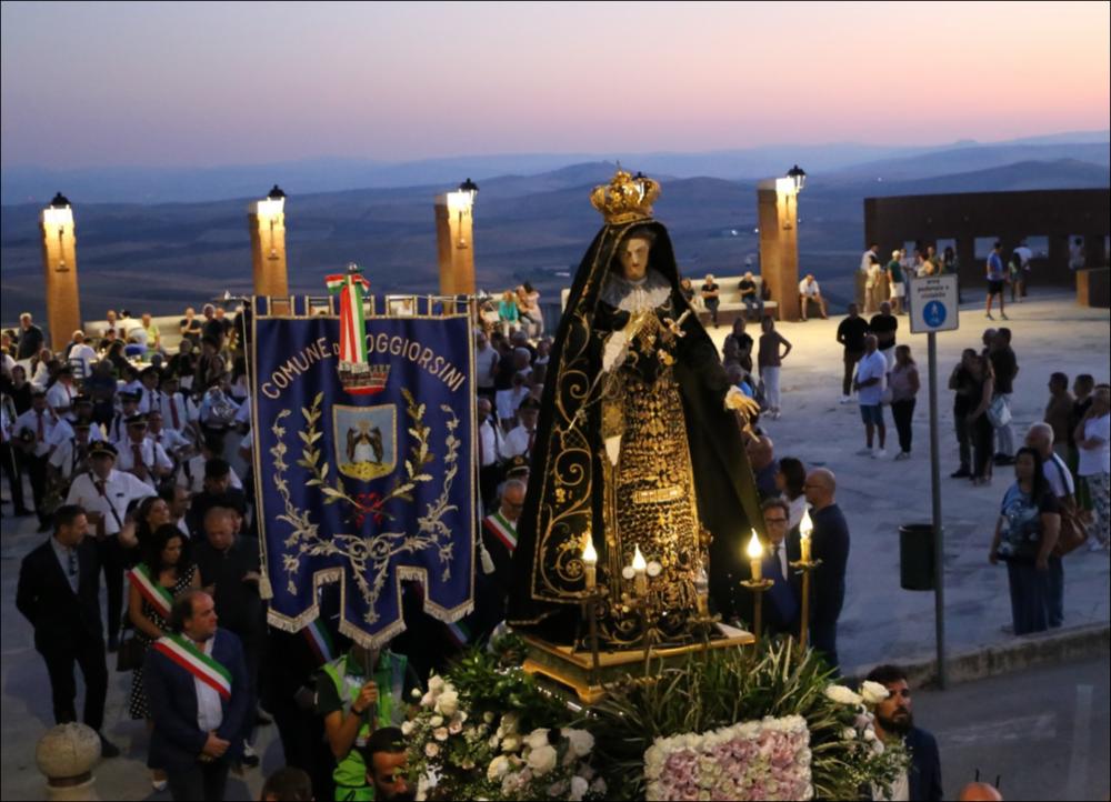 <div class="ql-editor"><div>L'immagine digitale immortala la statua della Madonna che sfila in processione in occasione della Festa Patronale di Maria Santissima Addolorata celebrata a Poggiorsini (BA) nell'anno 2024.</div><div>La festa si celebra tradizionalmente il 9, 10 e 11 agosto. Secondo la tradizione orale, le sue origini risalgono alla prima metà del Novecento quando, a causa delle limitate risorse economiche, veniva organizzata ogni due o tre anni. Solo in tempi più recenti la festa è diventata un appuntamento annuale, consentendo una più stabile conservazione e trasmissione delle pratiche religiose.</div><div>La dimensione spirituale è centrale e si prepara già dal mese di luglio con momenti di preghiera. Nei giorni della festa si...