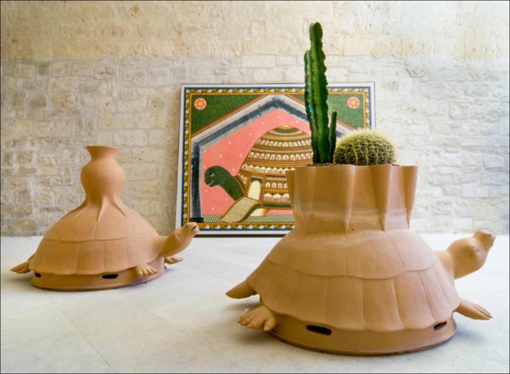 L'immagine digitale in oggetto, scattata in occasione della mostra “Le culture sacre dell'Arte” dell'artista pugliese Tarshito, realizzata dal 23 novembre 2008 al 25 gennaio 2009 negli spazi del Castello di Trani, coglie da vicino due sculture in terracotta realizzate in India nel 2000 da Lala, Jagdish, Shekhar, Kumar Pandit, Bihar. “Tartaruga con giardino” e “Tartaruga con vaso”, rispettivamente in primo e secondo piano, nascono da un'idea dell'artista e conservano un forte significato intrinseco che va oltre il bene fisico, legate ad un concetto più profondo come i molti animali che l'artista recupererà nella sua arte. Sulla corazza di entrambe le due tartarughe compare un piccolo vaso, elemento iconografico che spesso si ritrova nei lavori dell'artista. Il vuoto all'...