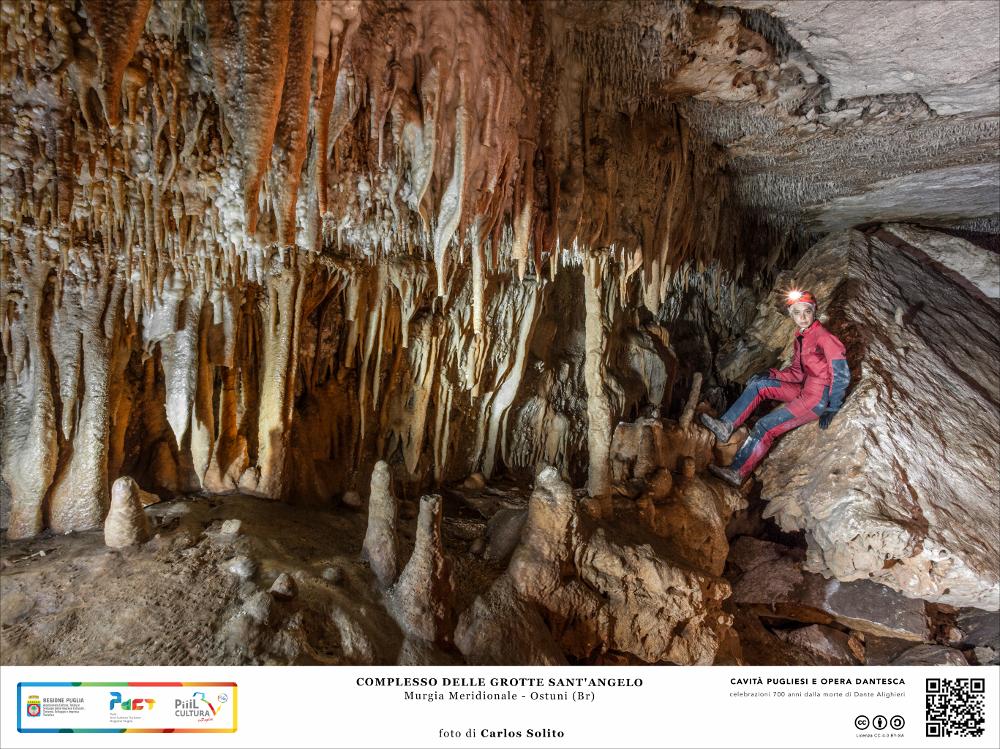 Una sequenza fittissima di punte acuminate si aggrappa alla parete e al soffitto di questa ampia cavità del Complesso delle Grotte di Sant’Angelo a Ostuni.
Da un pozzo di circa 4 metri si accede alla profonda caverna stracolma di depositi terrosi. La grotta principale si dirama a sinistra per una cinquantina di metri attraverso cunicoli stretti e angusti e a destra con un pendio che immette in una grande cavità dalla quale si diramano altri cunicoli per un percorso di quasi 800 metri.
Sono numerosi i resti faunistici e ceramici emersi dalle campagne di scavo che testimoniano la frequentazione di queste grotte fin dalla lontana preistoria.
L’immagine digitale fa parte della raccolta di fotografie prodotte da Carlos Solito per il Progetto digitale “Sillabario sotterraneo ...