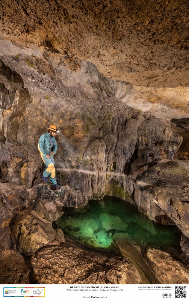 Le pozze d’acqua, che sono poste nelle zone più buie della grotta, anticamente erano usate per le abluzioni degli ammalati che cercavano conforto nella fede. Sono ampie vasche di acqua che amplificano la luce e diventano portali per mondi misteriosi.
La trasformazione di questo antro in un luogo di culto micaelico è avvenuto durante il Medioevo, quando, secondo la leggenda, San Michele sarebbe entrato in questa grotta seguito da un grosso toro che rimase incastrato nella roccia. Il padrone del toro, non appena riuscì a liberarlo, fu inondato dalla luce abbagliante dell’Arcangelo. Il racconto del pastore portò i compaesani alla grotta dove videro San Michele in ginocchio con le mani posate nel punto esatto in cui iniziò ad affiorare acqua di sorgente. 
L’immagine digital...