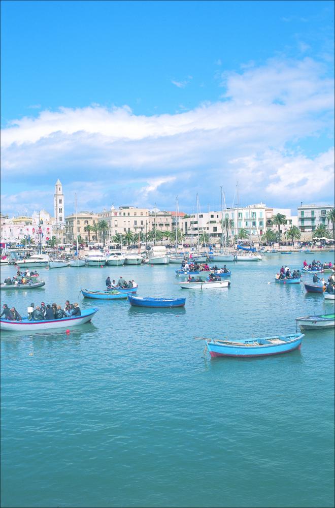 La fotografia è parte della ricca raccolta fotografica “Puglia per tutte le Stagioni” vol. 2, prodotta dall'Assessorato al Turismo e Industria Alberghiera della Regione Puglia e creata per raccontare la Puglia attraverso immagini diverse suddivise in 5 settori principali: Città e Paesi, Settimana Santa, Territorio, Feste – Sagre – Tradizioni, Mercati – Prodotti – Cucina. L'immagine, scattata a Bari, riproduce uno dei luoghi più celebri della città, vicino al piccolo porto tra il mercato dei pescatori e il Teatro Margherita, dove sono attraccati i pescherecci caratteristici. La mattina dell'8 maggio, dopo la Messa solenne e la Benedizione del Mare alla presenza delle più alte cariche ecclesiastiche della città, la statua si imbarca dal molo del Lungomare su un pescherecc...