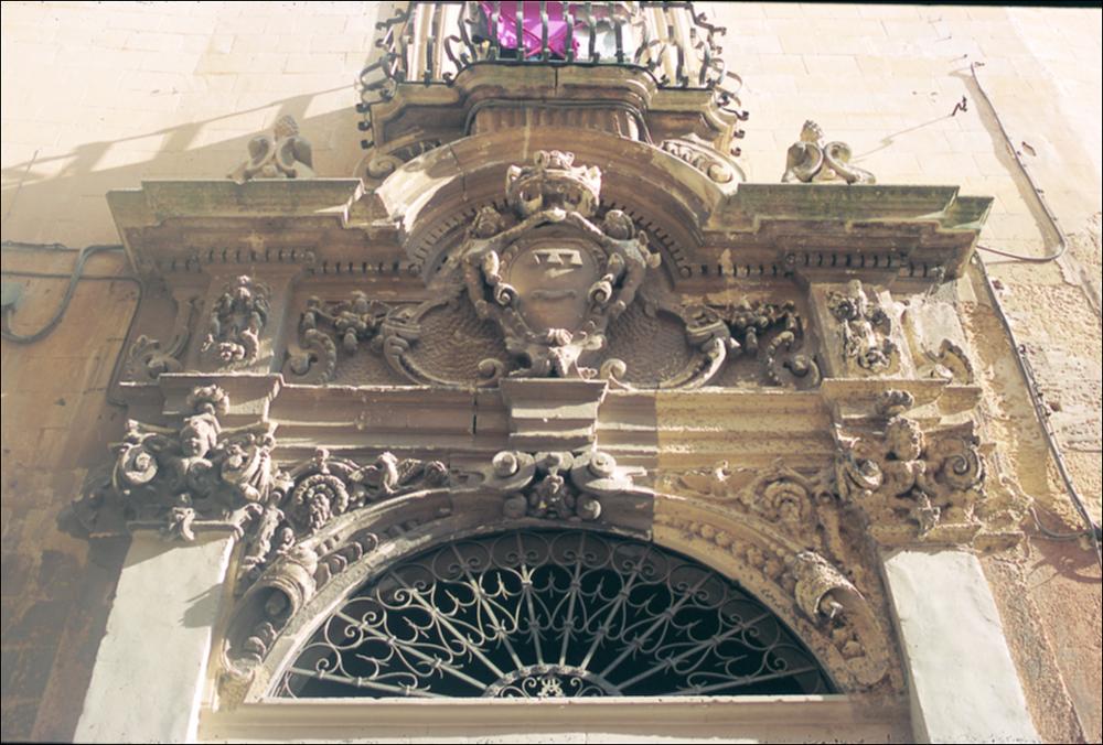 La fotografia è parte della ricca raccolta fotografica “Puglia per tutte le Stagioni” vol. 2, prodotta dall'Assessorato al Turismo e Industria Alberghiera della Regione Puglia e creata per raccontare la Puglia attraverso immagini diverse suddivise in 5 settori principali: Città e Paesi, Settimana Santa, Territorio, Feste – Sagre – Tradizioni, Mercati – Prodotti – Cucina. L'immagine immortala dei fregi barocchi, particolare su un palazzo del centro storico di Lecce. Passeggiando per le vie del borgo antico è possibile imbattersi nelle maggiori bellezze architettoniche cittadine, caratterizzate da una varietà e commistione di stili ed epoche, tra le quali certamente primeggia il barocco. Il centro storico della città è piccolo e luminoso, interamente realizzato in pietra ...