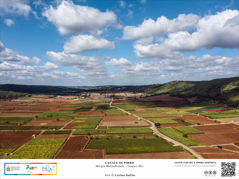 Il paesaggio è incantevole: la mano operosa dell’uomo ha dato vita a un vero e proprio mosaico di tessere dalle infinite sfumature dei colori della terra. Un'intensa sensazione di pace e di quiete pervade l’aria.
Facendo un passo indietro nel tempo non è difficile immaginare Pirro, i suoi elefanti e il suo numerosissimo esercito attraversare queste terre per contrastare l’avanzata romana.
Secondo una leggenda è proprio da questo episodio che il canale prenderebbe il suo nome.
Il Canale di Pirro, dunque, una delle più importanti depressioni carsiche presenti in Terra di Bari, a 300 metri sul livello del mare.
La maestosa dolina, ampia tra i 500 e i 1.500 metri e profonda circa 100 metri, si allunga per 12 chilometri tra i territori dei comuni di Putignano, Castellana Gro...