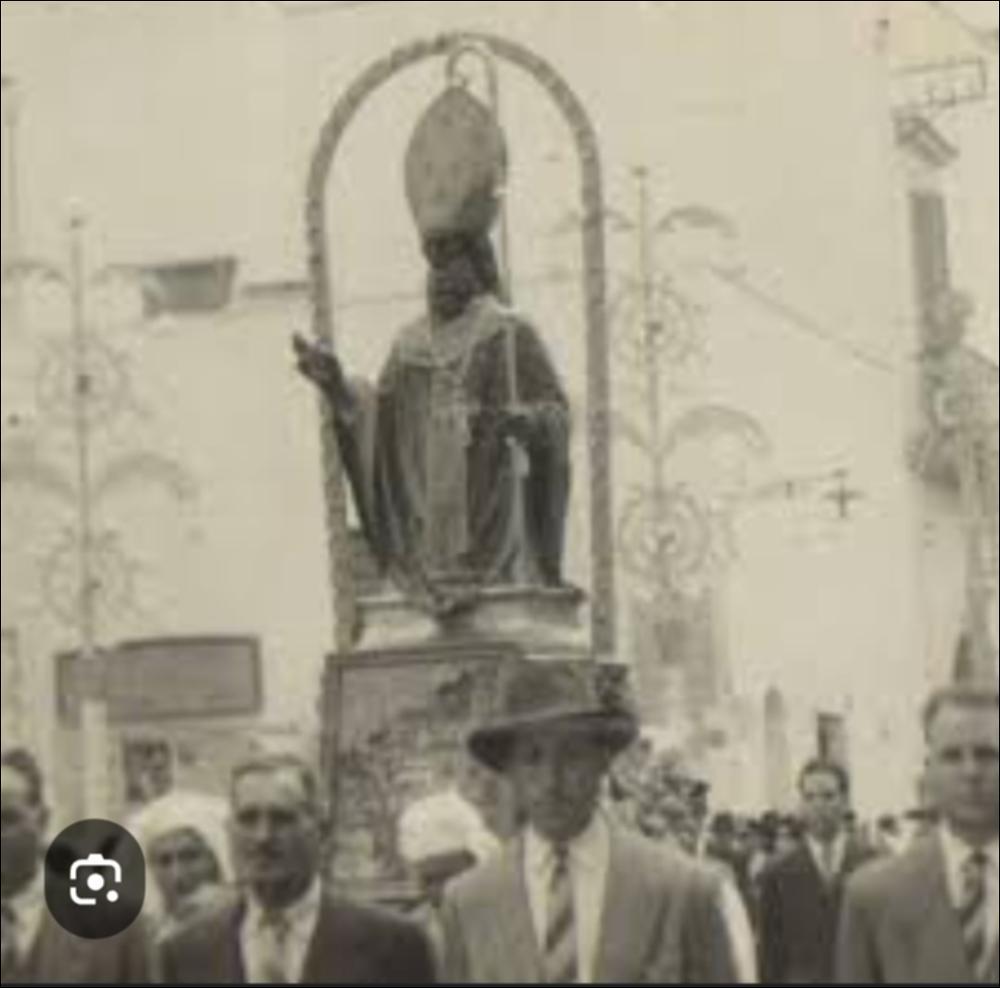 <div class="ql-editor"><div> La foto storica, risalente alla metà del secolo scorso, mostra la statua di Nicola Vescovo in processione per le vie del borgo cittadino in occasione della festa patronale in onore del Santo.</div><div>La festa dedicata a San Nicola Vescovo, patrono di Aradeo, rappresenta un importante momento di devozione e partecipazione comunitaria. Le celebrazioni comprendono la novena liturgica nei giorni precedenti la festa, la processione per le vie del paese e numerosi eventi civili, tra cui manifestazioni musicali, culturali e artigianali.</div><div>La secolare devozione della comunità di Aradeo verso San Nicola, vescovo di Myra, trova una significativa testimonianza nella cappella di San Nicola di Myra, situata lungo la strada che conduce...