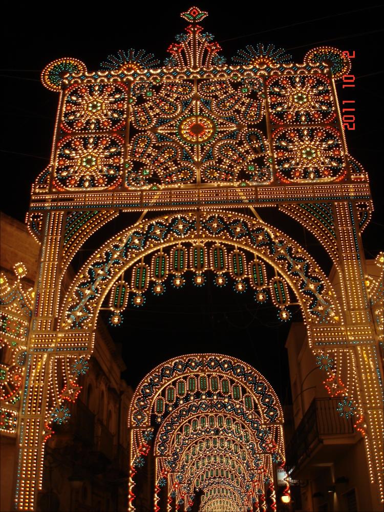 <div class="ql-editor"><div>Uno scorcio spettacolare di <strong>Corso Vittorio Emanuele</strong> illuminato per la Festa Patronale di Villa Castelli. Le luminarie, dai disegni elaborati e colorati, trasformano la via principale in un tunnel di luce, avvolgendo cittadini e visitatori in un’atmosfera di festa e meraviglia.</div><div><br></div><div>La Festa Patronale di <strong>Villa Castelli</strong> si svolge ogni anno dall’1 al 3 ottobre ed è uno degli appuntamenti più attesi e partecipati, non solo dai cittadini ma anche da tante persone provenienti dai paesi vicini. Conosciuta anche in dialetto come “Festa Bona”, è dedicata ai Santi Patroni, il Sacro Cuore di Gesù e la Madonna della Fontana, ed è stata istituita nel 183...