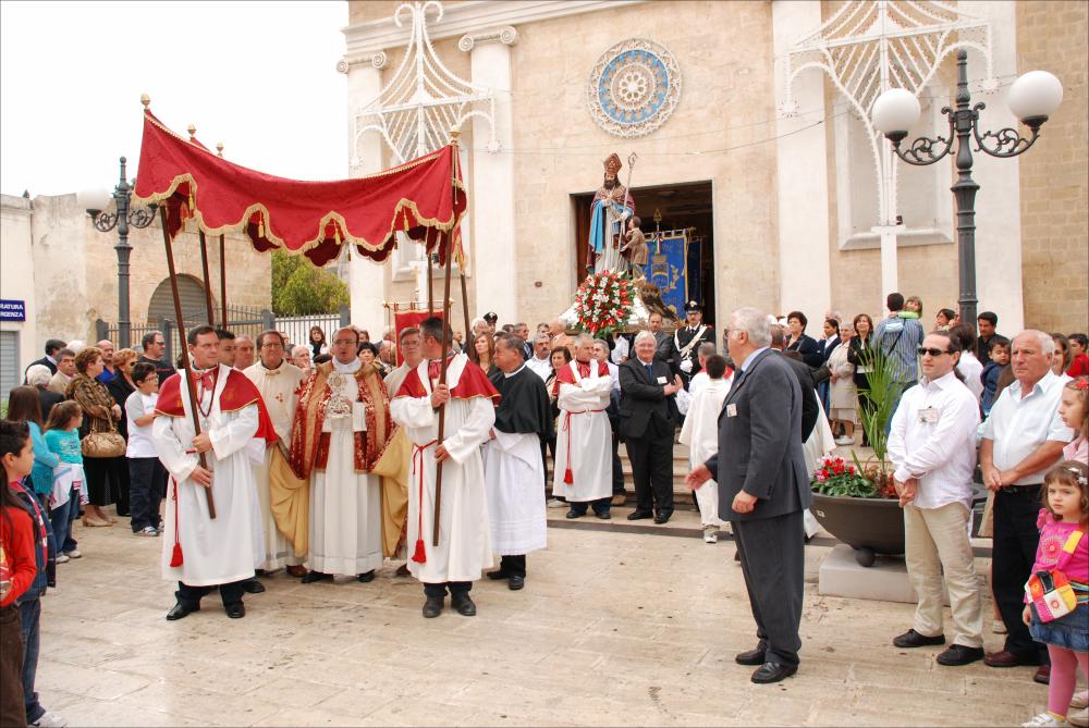<div class="ql-editor"><div>L'immagine mostra la statua di San Biagio che si avvia in processione partendo dalla Chiesa di Santa Maria delle Grazie a Carosino (TA).</div><div>La Festa Patronale di San Biagio, celebrata annualmente l’11 e il 12 ottobre, costituisce un articolato insieme di pratiche religiose e manifestazioni comunitarie dedicate al santo patrono. Le celebrazioni ruotano attorno ai solenni riti liturgici e alla tradizionale processione con la statua del santo lungo le principali vie del paese, affiancati da iniziative civili come concerti bandistici, luminarie, mercatini e momenti di aggregazione pubblica. In queste giornate l’intero centro abitato viene coinvolto, trasformandosi in uno spazio rituale condiviso dalla comunità.</div><div>L...