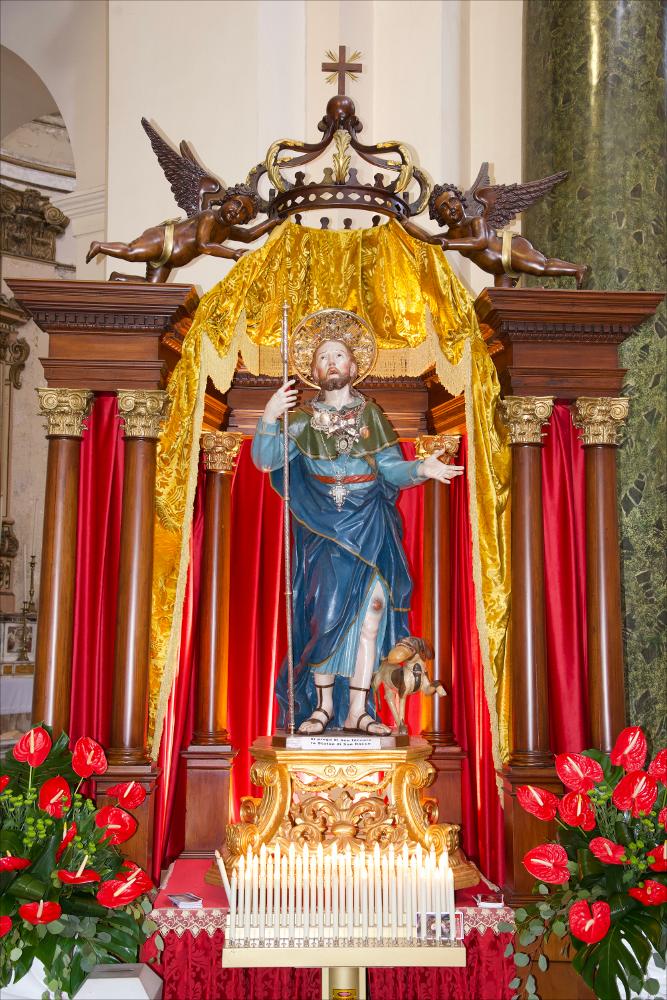 <div>Lo scatto fotografico presenta, in tutta la sua maestosità, la statua di San Rocco, Patrono della città di Ceglie Messapica.</div><div>Il culto di San Rocco a Ceglie Messapica, in provincia di Brindisi, è una delle tradizioni religiose più radicate della comunità locale. Il santo, noto per l’assistenza agli ammalati durante le epidemie, è venerato come compatrono della città con una devozione documentata fin dal XVI secolo.</div><div>Una Visita Apostolica del 1595 attesta la presenza di una statua del santo nell’antica Chiesa Madre e di una cappella a lui dedicata fuori dalle mura cittadine. Nel 1771 la statua fu portata in processione per la prima volta e, nello stesso anno, il sindaco Luca Felice Vitale, insieme a nu...