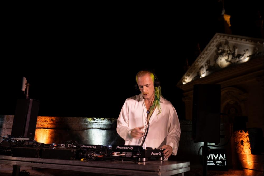 Uno scatto suggestivo riprende un momento della serata di VIVA! Festival 2021 del 5 agosto durante il dj set di Simone Benussi, in arte MACE, uno dei nomi più importanti della musica italiana del momento, che arriva a Locorotondo con il “VIVA! SPECIAL DJ SET”, realizzato in esclusiva per il festival.
La musica di Mace è fatta di contaminazioni derivanti dai suoi numerosi viaggi nel mondo. Come Deejay ha esportato nel mondo il collettivo RESET!, come producer ha collaborato con alcuni dei più grandi artisti italiani degli ultimi anni (Salmo, Ghali, Fabri Fibra, Marracash, Ernia, Guè Pequeno, per citarne alcuni). Il suo ultimo concept album, “OBE”, certificato disco di platino, contiene la partecipazione dei più̀ importanti esponenti della scena italiana e dopo una settim...